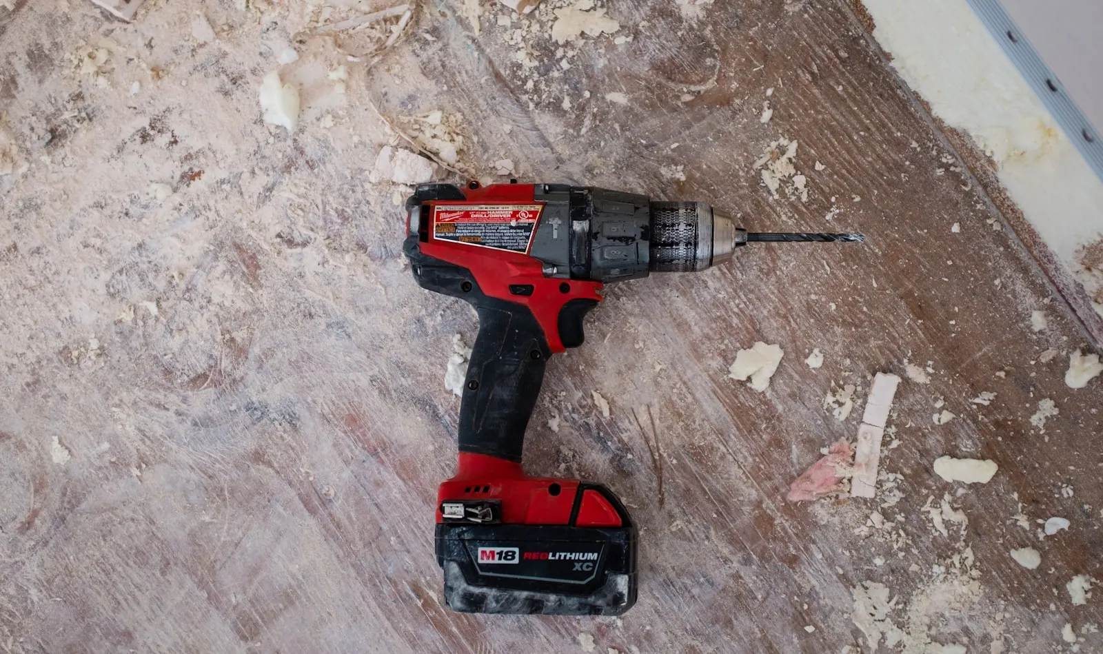 Installer's drill on the subfloor during a window replacement